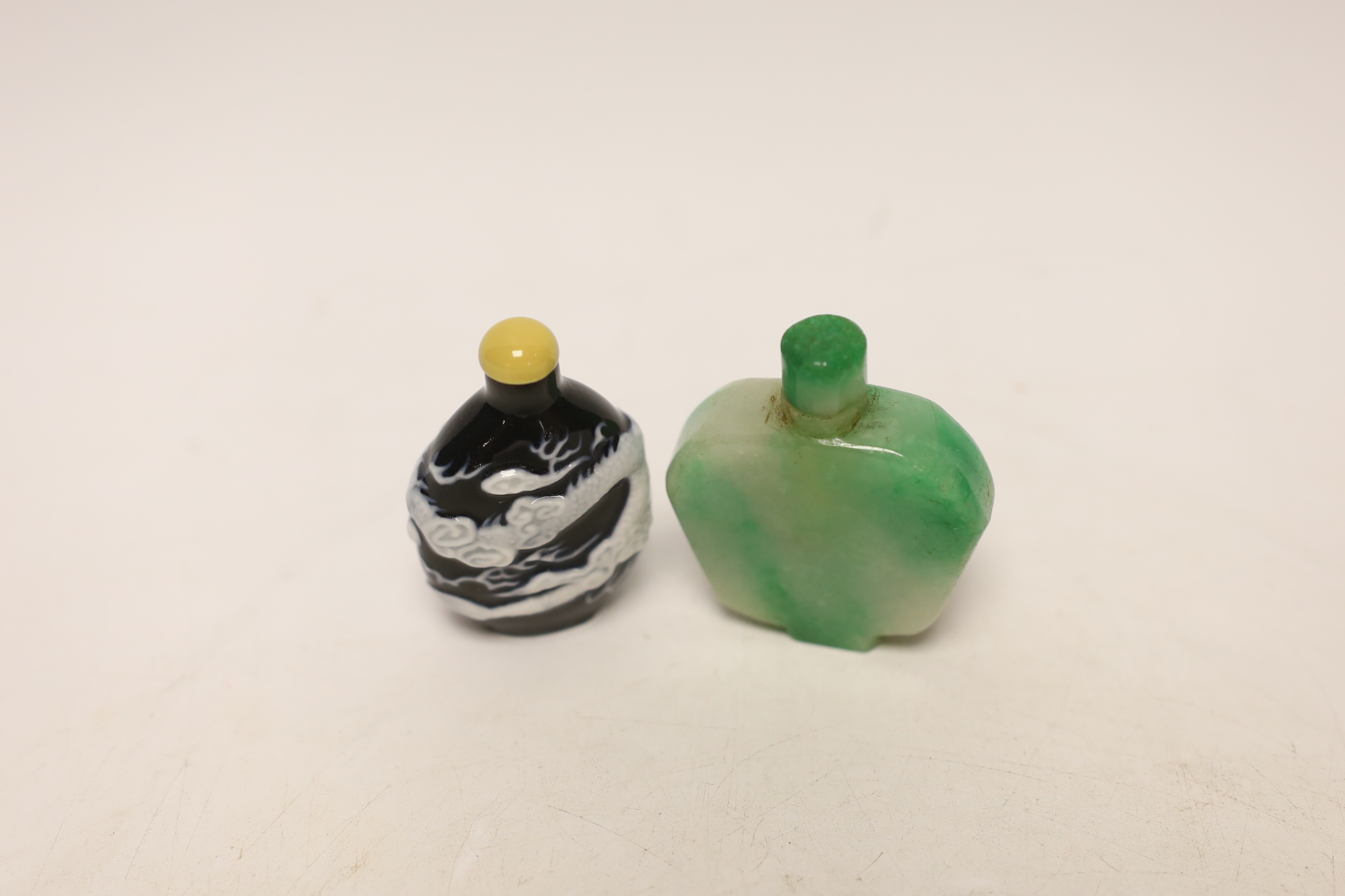 A Chinese jadeite snuff bottle and a slip decorated porcelain ‘dragon’ snuff bottle